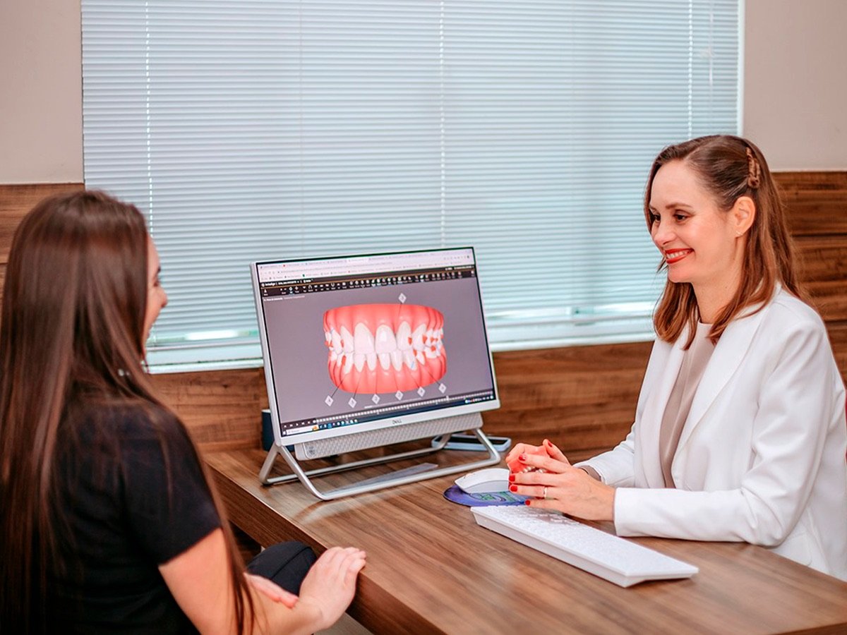 Profissional apresentando o planejamento digital do tratamento a uma paciente