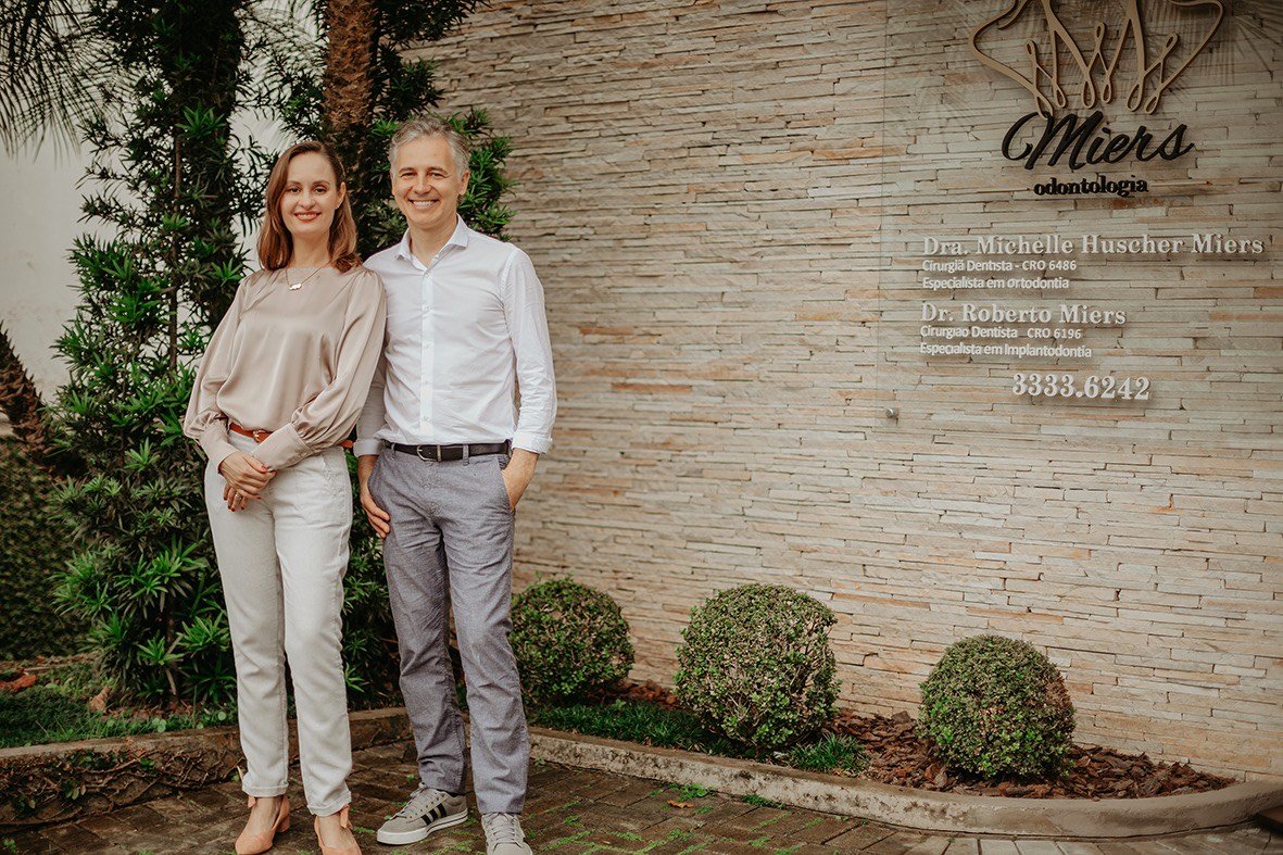 Dra. Michelle Miers e Dr. Roberto Miers em frente à fachada da Miers Odontologia